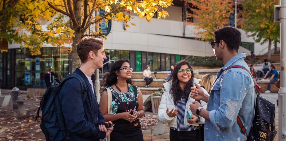 Students on campus chatting and laughing.