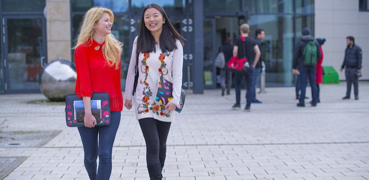 two students walking smiling