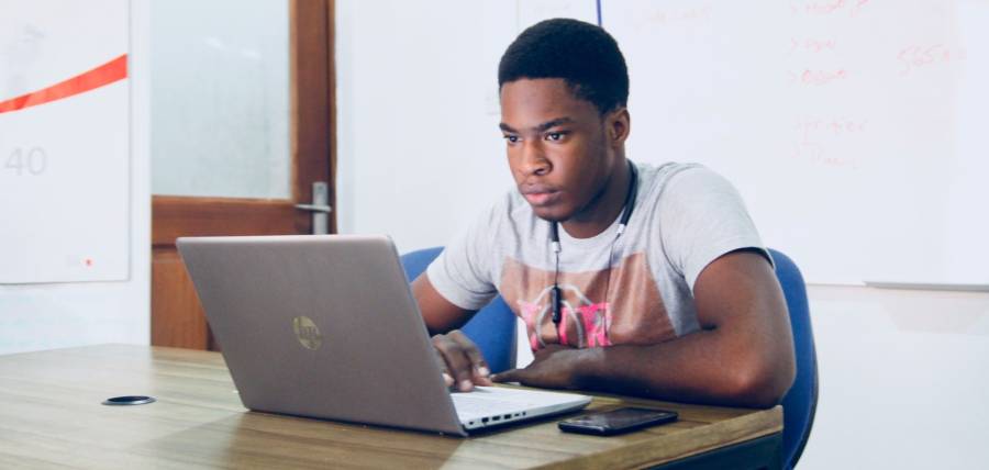 Man with headphones facing computer monitor