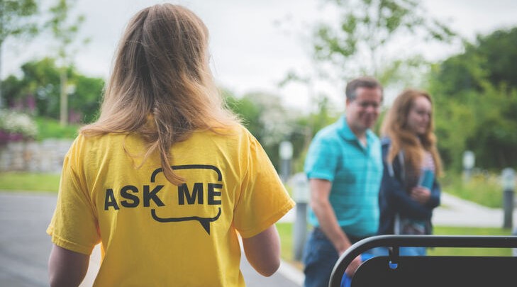 a student with 'ask me' on the back of their t shirt
