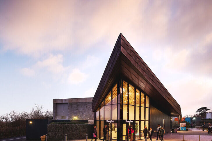Students walking outside the Penryn campus reception at sunset